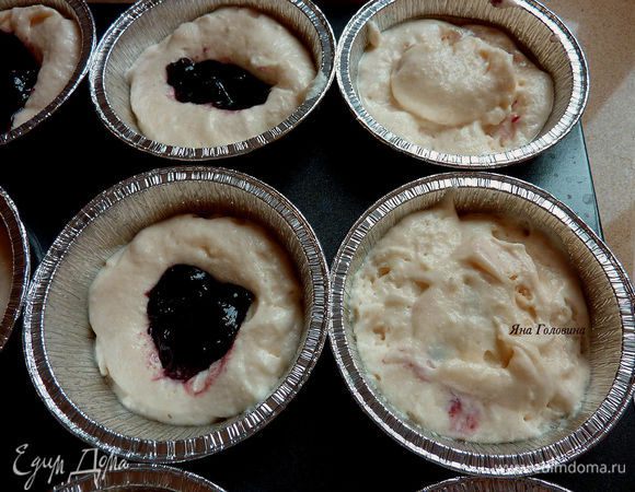 Формочки для кексов заполнить на 2/3 тестом, разложить на тесто по 1 чайной ложки варенья, по верх варенья распределить оставшейся тесто.