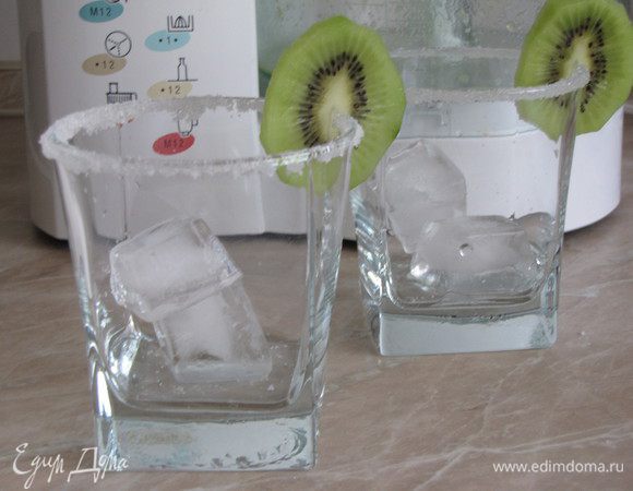 Из минеральной воды приготовить лед. В стаканы положить кубики льда, украсить кружками киви.