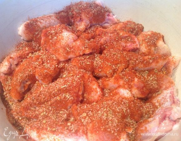 Натрите куриные крылышки сухой смесью.