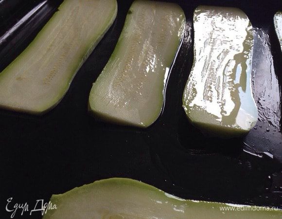 Противень застелить бумагой для выпечки, разложить кабачки, немного смазать оливковым маслом,посолить. Поставить в разогретую до 180°C духовку на 5 минут.