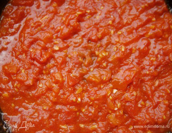 В сковороде раскалить 2 ст. л. растительного масла, добавить нарезанные помидоры,  чеснок и готовить, помешивая, 2 - 3 минуты.