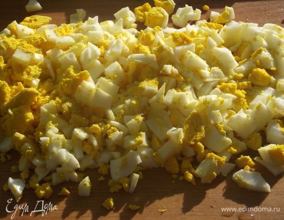 Сварить яйца вкрутую и охладить. Мелко порубить ножом. 