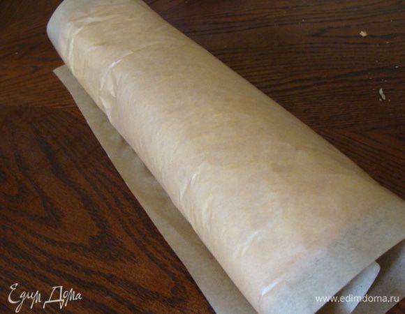 Аккуратно снимаем верхний пергамент и сворачиваем бисквит в рулет. Даем полностью остыть.
