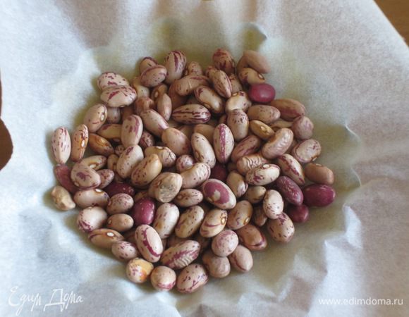 Сверху положить пергамент, насыпать фасоль и выпекать в разогретой до 180 °С духовке 12 минут. Убрать пергамент с фасолью и выпекать ещё 3 минуты.
