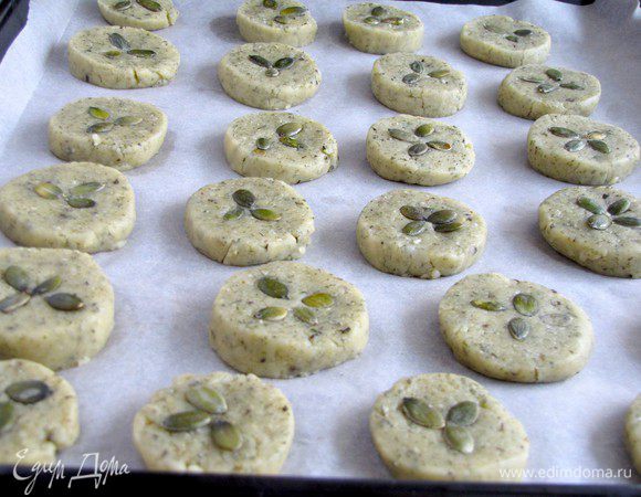 Затем колбаски нарезать небольшими кружочками, толщиной 1-1,3 см. Уложить их на противень, застеленный пекарской бумагой. В каждый кружочек вдавить несколько тыквенных семечек. Выпекать примерно 25 минут при температуре 190 град. до зарумянивания.