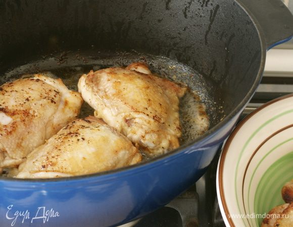 В большую сковороду с тяжелым дном положить оба вида масла. Куриные бедрышки обжарить частями (не перегружая сковороду). Сначала выкладываем бедрышки кожей вниз и обжариваем 5 минут на среднем огне, затем переворачиваем и обжариваем еще 5 минут на другой стороне. Курочка должна приобрести красивую золотистую корочку! Обжаренную курицу переложить в отдельное блюдо и поддерживать в теплом виде.