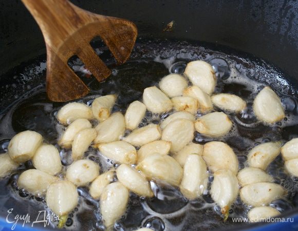 В сковороду выложить чеснок. Огонь убавить до слабого. Обжаривать зубчики чеснока минут 5-7, постоянно помешивая (!!!). Это важно, иначе чеснок подгорит, а он должен стать равномерного золотистого цвета.