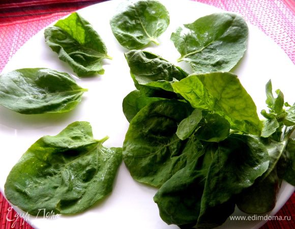 Выкладываем шпинатные листья по кругу и на дно большого блюда.