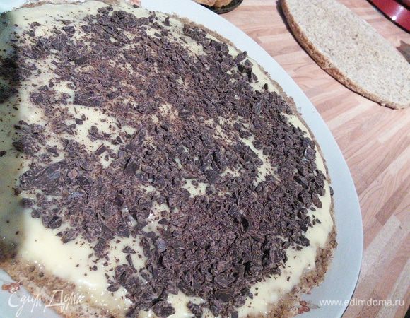 Первый корж выложить на блюдо, взбрызнуть половиной кофейно-ликерной  пропитки, смазать 3 ст. л. крема и посыпать половиной шоколадной крошки. То же самое повторить и со вторым коржом. Накрыть последним коржом.