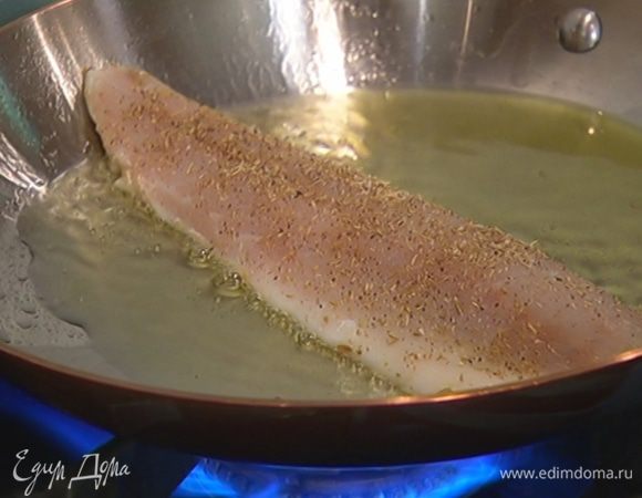 Разогреть в сковороде 1 ст. ложку оливкового масла, выложить рыбу кожей вниз и обжарить до готовности с двух сторон, затем переложить на бумажное полотенце.