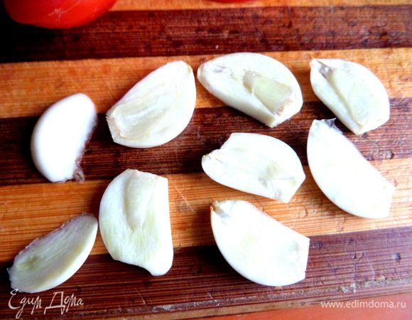 Чеснок почистить и поделить на плоские ломтики.