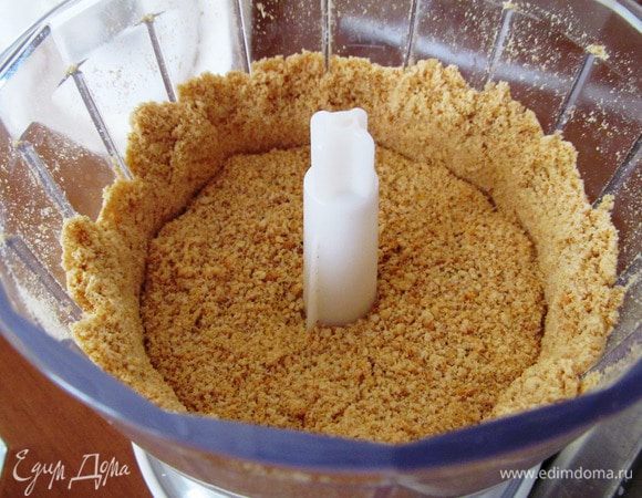 Духовку разогреваем до 160 градусов. Печенье измельчить в блендере, смешать с растопленным сливочным маслом и апельсиновым соком. 