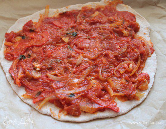 Разделить тесто на 2 части. Раскатать в тонкие лепешки. Каждую лепешку намазать соусом.