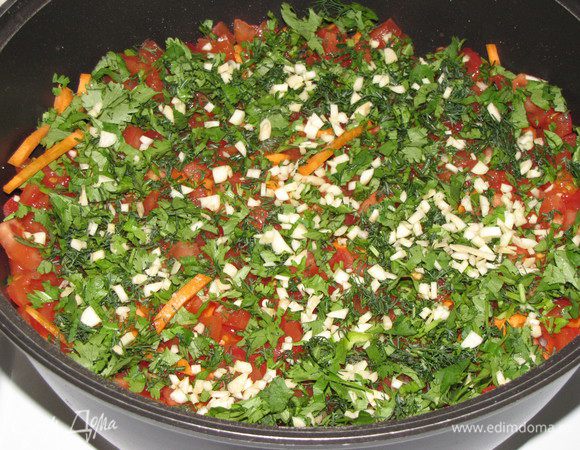 Поверх лука также плотно уложить слоями остальные компоненты: морковь, помидоры, нарезанную зелень. Зелень посыпать измельченным чесноком.