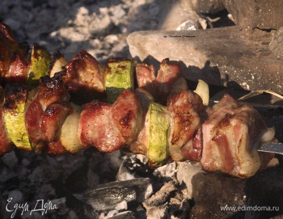 Подготовленное мясо равномерно нанизывайте на шампуры, перемежая колечками лука. Я добавила еще молодой кабачок, замариновав его в карри и апельсиновом соке. 
Нанизывать шашлык на шампуры следует вдоль волокон, предварительно смазав шампур растительным маслом.
 
