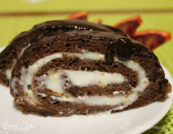 Остывший бисквит развернуть, смазать кремом, аккуратно завернуть и убрать в морозилку на 30 минут. Для глазури подогреть молоко до горячего состояния, к нему добавить масло и шоколад поломанный на кусочки. Перемешать до однородного состояния и покрыть рулет. Убрать в холодильник на ночь или на пару часов. 
   Приятного чаепития!!!