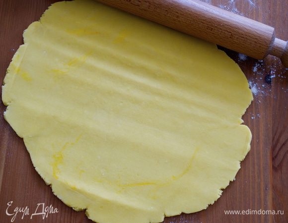 Включить духовку на 190 С. Тесто достать из холодильника и раскатать в пласт толщиной примерно 0.5 см. С помощью скалки перенести тесто в подготовленную форму для выпечки (24 см).