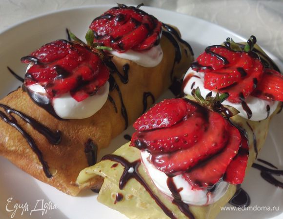 Шоколад растопить с 2-мя столовыми ложками сливок. Блинчики украсить взбитыми сливками, клубникой и полить шоколадом.