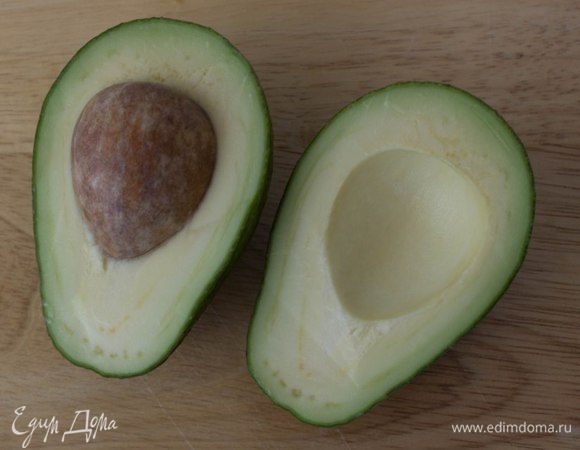 Авокадо разрезать на две части, удалить косточку, очистить и нарезать тонкими ломтиками.