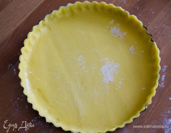 Наколоть тесто вилкой, накрыть пекарской бумагой и положить "утяжелитель" в виде фасоли, например... Поставить в разогретую духовку выпекаться на 20-25 минут (следить по своей духовке). Затем убрать фасоль и поставить в духовку еще на 5 минут. 