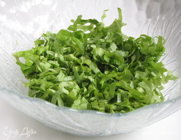 Салат-латук или другой листовой салат очень тонко порезать и выложить в миску.