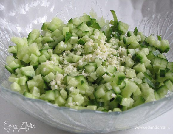 Добавить огурец, нарезанный небольшим кубиком, и мелко-рубленный чеснок. Все перемешать.