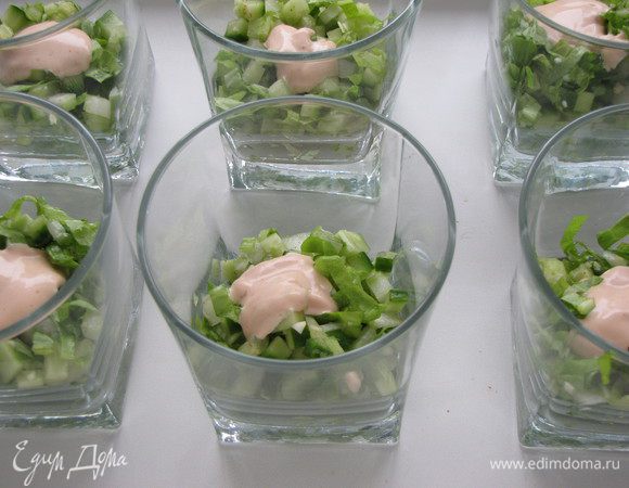 В широкие стаканы выложить салатную смесь. Добавить немного заправки.