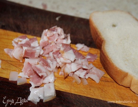 Пластинку бекона тоже нарезать кубиками. Кусочек батона замочить в воде, отжать и добавить к фаршу.