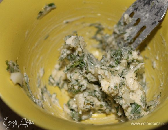 Для начинки, в размягченное масло добавить чеснок, пропущенный через пресс, мелко рубленную петрушку, розмарин, соль и перец. Хорошо все перемешать.