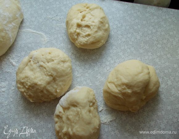 Стол обильно посыпаем мукой. Выкладываем муку и хорошо замешиваем тесто, что бы вышел весь воздух. Делим тесто на шарики. Духовку разогреваем до 180 градусов.