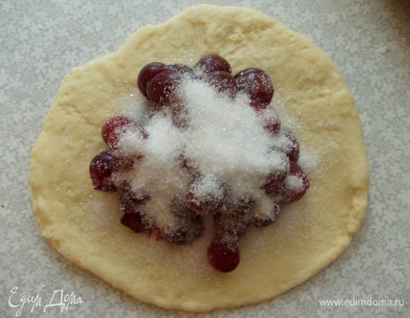 Тесто раскатать, выложить вишню, обильно посыпать сахаром. Скрепить хорошо края.