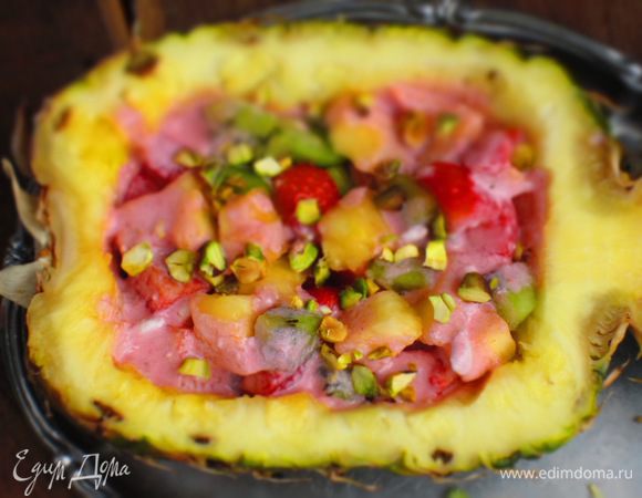 В ананас выложить фрукты,полить клубничным соусом и посыпать рубленными фисташками.Приятного аппетита:))