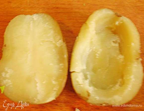 С готового картофеля слить воду, дать немного остыть. Разрезать картофель пополам. Вынуть серединку оставляя стеночки толщиной 5 - 10 мм.  У нас получаются лодочки.