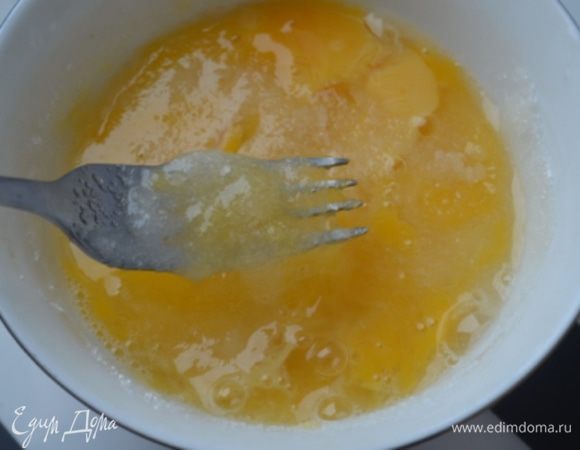 Вилкой яйца взбить с сахаром, молоком и растопленным масло.