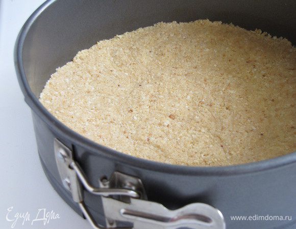 Выложить смесь в форму со съемными бортиками (диаметр формы 20 см) и хорошо утрамбовать дном стакана или руками. Поставить форму в холодильник, пока будем заниматься начинкой.