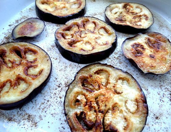 Выкладываем дольки баклажана на расстоянии обжаренной стороной вверх.