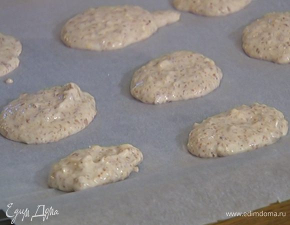 Противень выстелить бумагой для выпечки и ложкой выложить миндальное тесто в форме небольших лепешек.