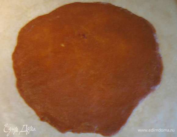 Раскатываем тесто на пергаменте диаметром 18-20 см. Шарик придавливаем рукой формируя лепешку присыпаем слегка мукой и тонко раскатываем. 