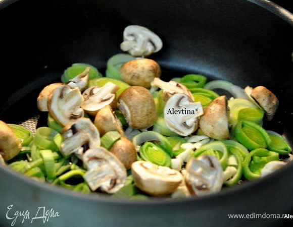 Разогреть сковороду с маслом, добавить порезанный лук порей, чеснок, грибы на пополам, тушить помешивая 10 мин. 
