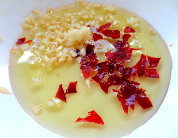 Для заправки смешаем масло с перцем чили и чесноком.