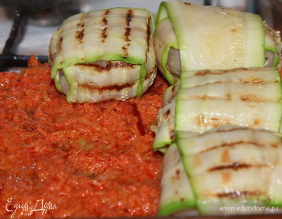 В форму для запекания выкладываем в один слой половину томатного соуса и выкладываем сверху "клубочки".