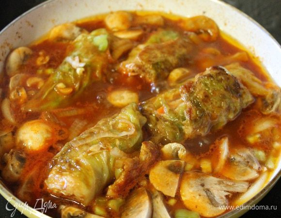 Затем добавляем грибы, перец болгарский, лук нарезанный полукольцами и мелко рубленый чеснок. И оставляем тушиться на медленном огне 30 минут, один раз рулетики перевернуть.