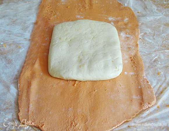 Через 2 часа вынимаем масляный блок  и раскатываем его на присыпанной мукой холодной доске в прямоугольник, у которого одна сторона вдвое длиннее другой.  На раскатанный масляный блок положить мучной блок. 
