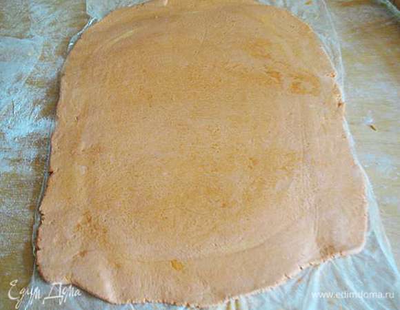 Первая раскатка. 
Раскатать тесто на в прямоугольник присыпанной мукой доске. У прямоугольника должна быть одна сторона в три раза длиннее другой. 

Я раскатывала между двумя  листами пленки, т.к. использовала неправильное масло для такого теста. 