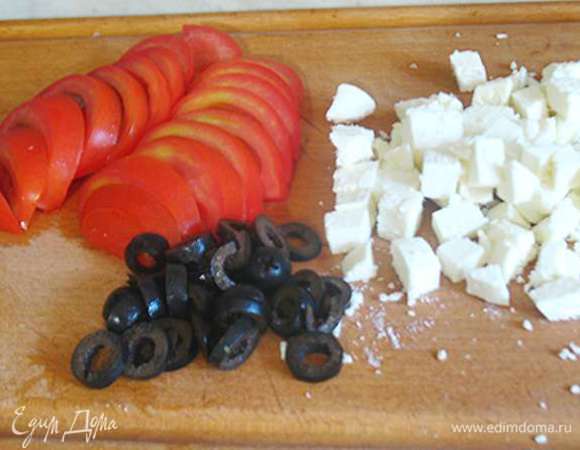 Помидоры крупные порезать полукольцами, маслины кружочками, а фету порезать на небольшие кусочки. 