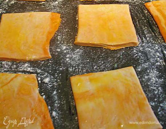 Тесто раскатать и нарезать на прямоугольники. Переложить на противень. Яйцо взбить и обмазать края теста. 