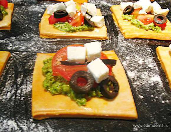 На песто кладем помидоры, маслины и фету. Сбрызгиваем маслом. Выпекать в предварительно разогретой до 230 градусов духовке минут 10 до золотистой корочки. 