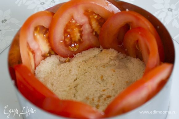 Теперь приступаем к сборке салата. На блюдо поставить кольцо (9 см) на дно положить ломтик хлеба (корочку срезать). Вдоль бортиков кольца выложить по кругу ломтики помидора.