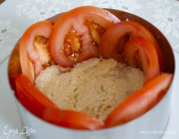 Теперь приступаем к сборке салата. На блюдо поставить кольцо (9 см) на дно положить ломтик хлеба (корочку срезать). Вдоль бортиков кольца выложить по кругу ломтики помидора.