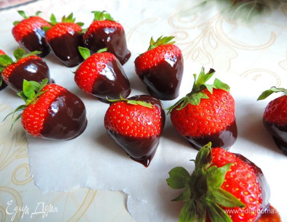 Каждую клубничку окунаем до половины в глазурь, держа ее за хвостик. Выкладываем ягодки на пергамент, чтоб глазурь немного застыла.